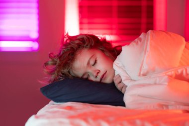 Yatakçı çocuk. Çocuk uyuyor, kestiriyor. Çocuk yatakta uyuyor.