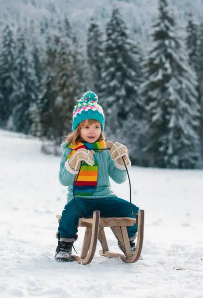 子供の男の子は冬に眠っていた 冬に雪のスライドに乗って子供 素晴らしいクリスマスシーン — ストック写真