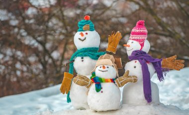 Mutlu kardan adam çift ve noel hediyesi ile kardan adam çocuk kış Noel manzara ayakta. Yeni yıl tebrik kartı. Mutlu Noeller ve mutlu yeni yıl tebrik kartı. Kış Satılık afiş