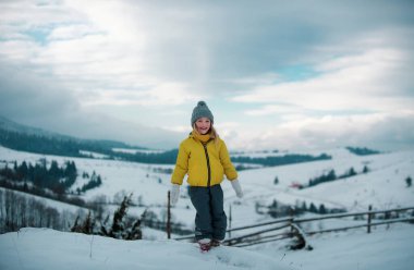Güzel, neşeli kız. Kış ormanında ödüyorum.