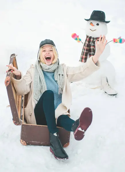 Portrait of adventure woman in winter mood. Winter vacations. Traveling among stunning winter landscape. Happy young girl playing in fresh snow and making snowman outdoor in nature