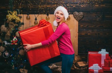 Büyük Noel hediyesi. Kırmızı Santa şapka mevcut tutan kadın. Noel hazırlık. Yeni yıl kutlama lüks kız