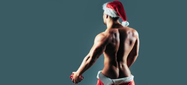 Noel Baba şapkalı geylerin arkası. Yeni yıl şeritleri ve yetişkinler için hediyeler. Noel 'de kas geyliği. Kaslı vücutlu Noel Baba gay. Noel partisi ve seks oyunları. Yakışıklı seksi noel baba gay kulübü afişi