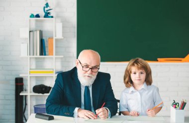 Okuldaki mutlu çocuk. Öğretmenin öğrenmesine yardım et. Eğitim, öğretmenlik, ilkokul