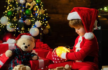 Çocuk Noel ağacının yanında oynuyor. Mutlu ve parlak noeller. Çocukluk aktiviteleri ve oyun. Güzel bebek, Noel 'in tadını çıkar. Aile tatili. Çocukluk anıları. Noel çocuk Noel 'i evde kutluyor..