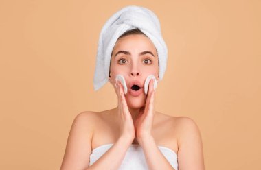 Temiz ciltli heyecanlı güzel bir kadın. Güzel kız yüz bakımı. Yüz bakımı. Spa cilt bakımı, güzellik tedavisinden sonra saç havlusu giyen güzel kadın. Güzel mükemmel ten, izole edilmiş bej