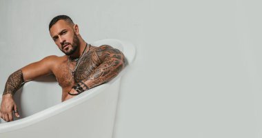 spa ve hijyen. banyoda dinlenmek için zaman. güven karizması. acımasız sporcu. Steroid. atletik vücutlu kaslı adam. banyo küvetinde dövme adam seksi abs. temiz ve taze kalın. kopyalama alanı.