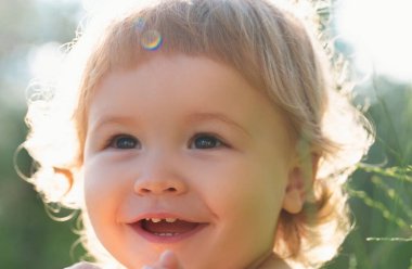 Portrait of a happy laughing child. Close up positive kids cropped face. Baby smiling, cute smile
