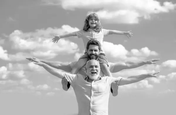 Fathers day. Father and son with grandfather raising hands or open arms flying. Men generation