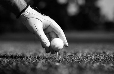 Golfçü golf sopasıyla golf sahasına giriyor. Elindeki golf eldiveni