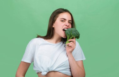 Brokoli yiyen mutlu ve güzel bir kadının portresi. Sağlıklı gıda, sağlıklı yaşam.