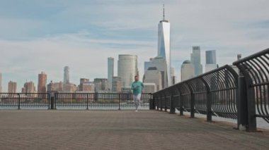 Kaçak adam. Manhattan şehir manzarası yakınında antrenman yapan New York 'lu koşucular. Formda adam antrenman yapıyor. New York şehrinin önünde koşan bir koşucu. Hudson, New York 'ta koşucu egzersizi yapıyor. Koş adamım.