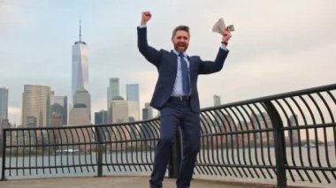 Amerika 'da iş. New York 'ta parası olan heyecanlı bir iş adamı. Para, Amerikan doları konsepti. Amerikan doları. İş adamı para kazanıyor. Bir dolar, New York 'ta kolay para. Şanslı olgun iş adamı