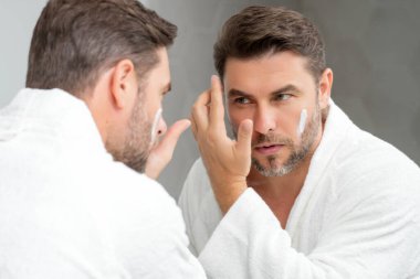 Erkek kozmetiği. Güzellik uzmanı yüz kremi sürüyor. Cilt bakımı kozmetik. Erkek kozmetik yüz kremi. Yüz kremi, nemlendirici krem. Yüz kremi cilt bakımı için. Kırışık kozmetik yüz tedavisi