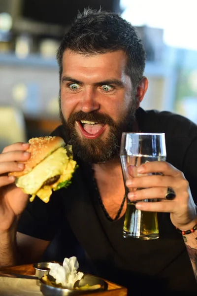 ハンガーマンはビールを飲むハンバーガーを食べる おいしいハンバーガーを食べる ハンバーガーでディナー ランチにハンバーガー おいしいグルメ チーズバーガーかハンバーガー バーガーサンドイッチ 食べ物 食事について おいしいバーガーを食べる男 — ストック写真