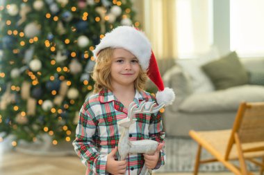 Noel 'i kutlayan küçük bir çocuk ya da evde Noel ağacı olan bir çocuk.