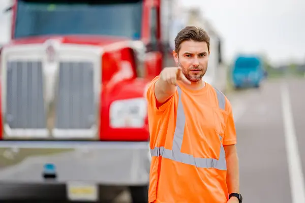 Men driver near lorry truck. Man owner truck driver in safety vest near truck. Handsome hispanic man trucker trucking owner. Transportation industry vehicles. Handsome man driver front of truck
