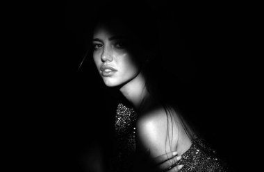 Kızların yüzü gölgeli, çekici bir kadın model. Gölgedeki kadın. Yüzünde gölgeler olan kadın model. Işıklı dramatik siyah stüdyoda baştan çıkarıcı ve şehvetli görünüyor.