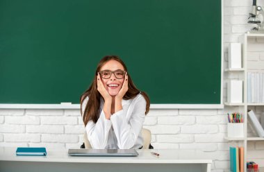 Sınıfta okuyan gülümseyen genç üniversite öğrencisinin portresi.