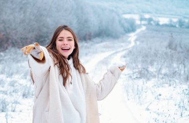 Mutlu kış kadını karlı zemin üzerine. Avrupa şehri sokakta poz Kazak giymiş uzun saçlı açık güzel kız. Noel, kış tatil kavramı. Kar yağışı. Kopya alanı