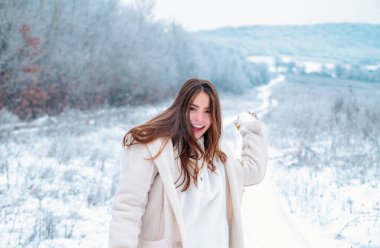 İyi kışlar. Karla oynamak ve kış parkında eğlenmek. Kış yolculuğunda gülümseyen kız. Kış tatilinde eğleniyorum. Havanın ve karın tadını çıkarıyorum.