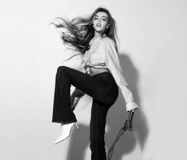 Hareket modeli. Moda elbisesi giyen çekici bir kadın. Pembe gömlekli ve kot pantolonlu moda kadını.