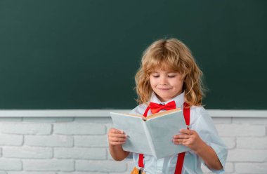 Okullu çocuk sınıfta bir kitap okuyor. Okuldaki sevimli çocuk. Çocuk sınıfta tahtayla ilgili bir şeyler öğreniyor. Okula dönüyorum, okuldaki ilk günüm.