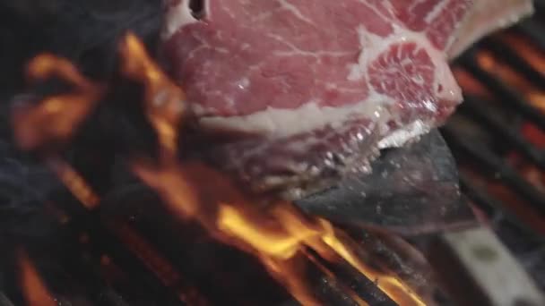 烤肉用火烤着 烤肉用火烤着 牛肉牛排放在烤架上 肉蒸在烤架上烹调 把烤好的肉放进火里 牛肉牛排在烧烤时烤焦了 上的牛排 — 图库视频影像