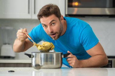 Aşçı mutfakta yemek pişiriyor. Şef aşçı tencereli bir yemek hazırlıyor. Menü tarifi sağlıklı yemek. Şef modern mutfakta yemek pişiriyor. Olgun aşçı mutfakta yemek hazırlıyor.