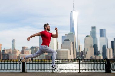 Spor habercisi. Adam kaçıyor. Açık havada koşan formda bir erkek spor modeli. Çekici bir adam hızlı koşuyor, dışarıda antrenman yapıyor, New York caddesinde koşuyor. Fitness, sokakta koşan sağlıkçı