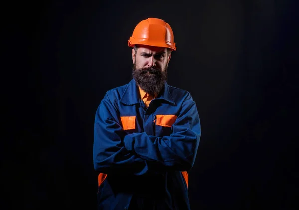 Builder worker in construction helmet. Builder foreman or repairman in builders uniform. Worker in studio. Construction manager, builder in helmet. Male builder engineer