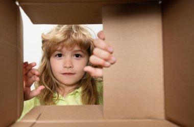 Neşeli şirin çocuk hediyesini açıyor. Kutunun içinden görüntüle. Paketler, teslimat servisi.