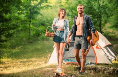 Romantic couple walking on camping, man with guitar. Outdoor adventure with friends on nature