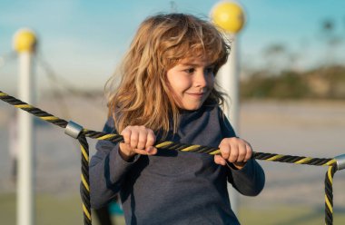 Çocuk parkında oynarken sevimli küçük çocuk komikliği. Yaz, çocukluk, eğlence ve çocuk konsepti