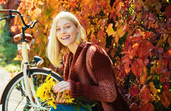 Autumn woman in autumn park with red pullover. Beautiful Autumn Woman with Autumn Leaves on Fall Nature Background. Pretty tenderness model looking at camera
