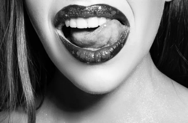 Close up of sexy open mouth with tongue lick white teeth. Sensual red lips. Sexy lips, suck