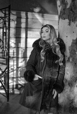 Yumuşak kürklü güzel sarışın genç bayan. Kış ve sonbahar modası. Uzun saçlı ve profesyonel makyajlı güzel seksi manken kız. Şehir caddesinde zengin kürklü şık bir kadın.