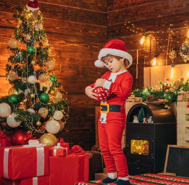 Noel Baba çocuk Noel 'i evde kutluyor. Aile tatili. Çocuk şirin neşeli çocuk Noel ağacının yanında oyun oynuyor. Mutlu ve parlak noeller. Açılış hediyesi. Güzel bebek, afiyet olsun..