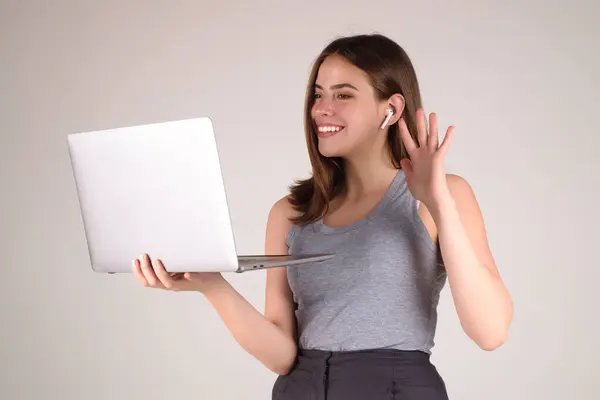 Happy Student. Woman Student in white t-shirt holding laptop and laptop, isolated over gray background. Student posing in studio. Portrait of student having video-call. Students time
