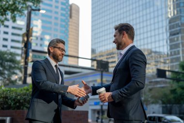 Başarılı bir takım çalışması. İş adamları el sıkışıyor. Takım elbiseli işadamları dışarıda el sıkışıyor. El sıkışalım. İki iş adamı, iş adamlarının başarısı için işbirliği.
