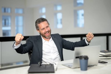 Modern ofis. İşletme takımında başarılı bir beyaz iş adamı dizüstü bilgisayar kullanıyor, uzaktan kumandayla çalışıyor, e-ticaret yapıyor. Heyecanlı Finans Denetçisi. Yönetim kurulu başkanının iş fikri var.