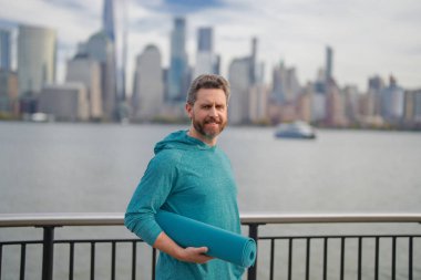 NYC 'de beden eğitimi son sınıf öğrencisi. Sağlıklı bir emeklilik hayatı. Aktif kıdemli adam dışarıda egzersiz yapıyor. Emeklilikten sonra aktif. Olgun emekli sporcu esneme egzersizleri yapıyor.