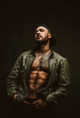 Siyah üzerine vahşi erkek modeli. Yakışıklı bir adamın portresi. Moda adamı. Erkeksi kendine güvenen çocuk.