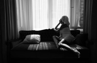 Girl resting and laying in cozy sofa bed in the luxury bedroom an easy morning. Attractive sexy woman relaxing wearing bathrobes and towels in hotel room. Lovely tenderness girlgriend.