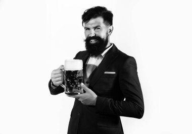 Sakallı ve bıyıklı hippi iş gününden sonra bira içer. Almanya Bavyera. Bira zamanı. Barmen elinde bir bardak bira tutuyor.