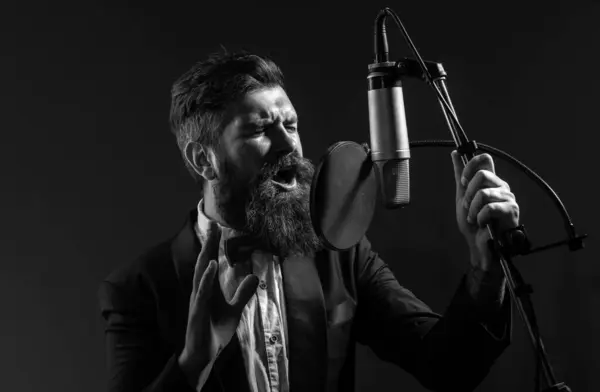 Singing man in a recording studio. Music festival. Expressive bearded man with microphone. Karaoke signer, musical vocalist