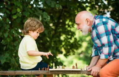 Yakışıklı büyükbaba ve torun birlikte vakit geçirirken satranç oynuyorlar. Küçük çocuk dedesi ile satranç oynuyor