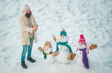 Mutlu kış zamanı. Noel kardan adam ile kapalı genç model adam Moda portre. Soğuk kış Parkı'nda kardan adam ile Yakışıklı Kış Adam