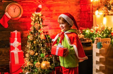 Mutlu noeller ve mutlu yıllar. Sevimli küçük çocuk çocuk noel ağacı yakınında oynamak. Çocuk evde kış tatili nin tadını çıkarın. Ev neşe ve sevgi yle dolu. Bu noel aileniz için en iyi dileklerimle.