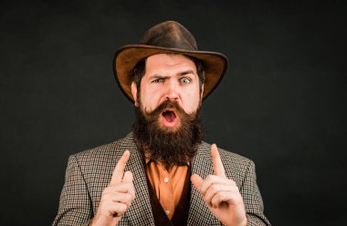 Funny brutal bearded hipster on isolated background. Close up photo of handsome funny man with beard in suit. Hand with fingers set into gun gesture